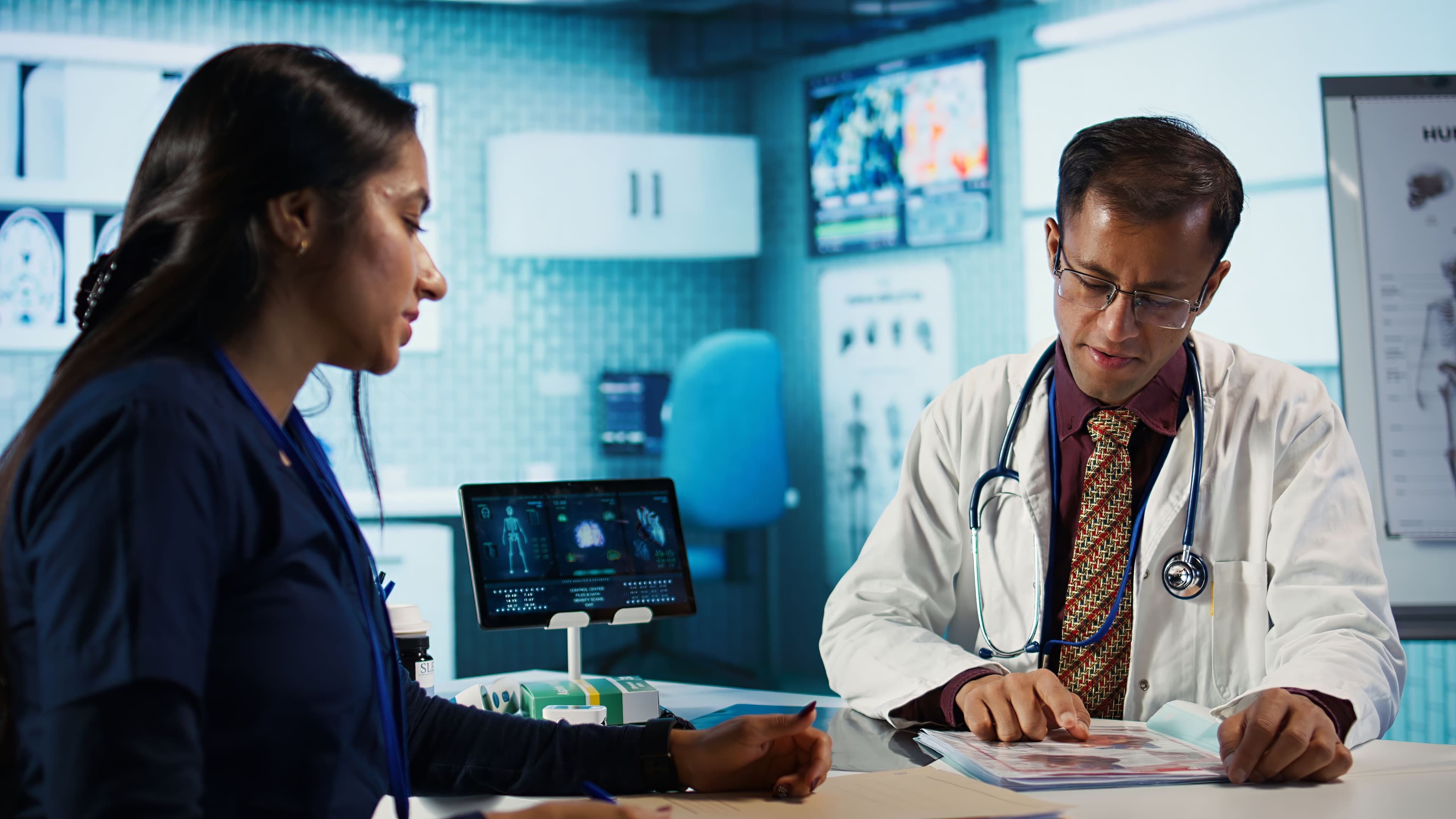 Healthcare professionals reviewing patient medical records and diagnostic information in a modern clinic, supporting collaborative care, treatment planning, and precision healthcare.